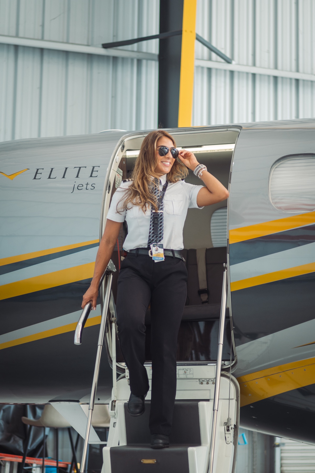 Maria Montero stepping off an aircraft in her pilot uniform